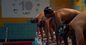 Sportowcy na pozycji startowej przed skokiem do wody